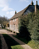 The exterior of a traditional country cottage on a grassy lane