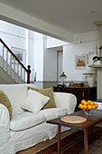 White sofa and staircase banister of Arundel reception room, West Sussex