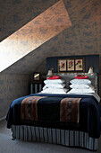 Wallpapered attic bedroom with dormer window