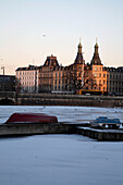 Zugefrorener Fluss und alte Renaissance-Gebäude bei Sonnenuntergang