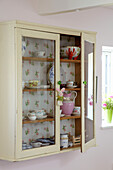 Wallpapered kitchen cabinet with chinaware