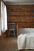 Simple blue chair next to double bed in country style bedroom