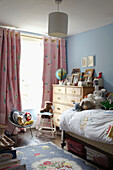 Pastel blue wall and pink curtains in child's room