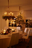 Lit candelabra above white Christmas dining table
