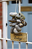 Pebbles hang on gate of Norfolk beach house, UK