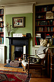 Armchair by lit fire in Brighton home, UK