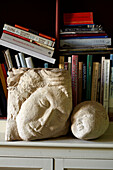 Two carved statues and bookcase in Brighton home, UK