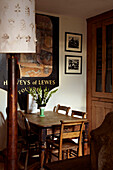 Wooden dining table and chairs with vintage artwork in Brighton home, Sussex, UK