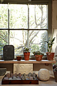 Carved stones on workbench with succulent plants in Brighton home, Sussex, UK