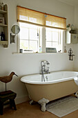 Freestanding roll top bath under window of West Sussex home, England, UK