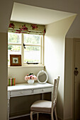 Dressing table and chair at dormer window of West Sussex bedroom England, UK