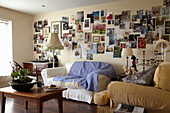 Sofa im Wohnzimmer mit fliederfarbenem Überwurf darüber Bildersammlung in einem Haus in Lincolnshire, England, UK