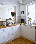 Weiße Küche mit Einbauschränken und Holzarbeitsplatte