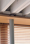 Close up detail of the support columns next to some Venetian blinds