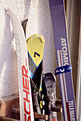 An outdoor detail of snow skis in a wooden rack