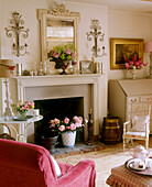 Arrangements of flowers in front of fireplace in traditional country style sitting room