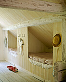 Schlafzimmer im Landhausstil mit zwei Kabinenbette, Holzvertäfelung, Holzfußboden, Kinderspielzeug, Kleidung und Holzbalken