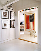 View through open doorway to United States flag hung in frame in hallway