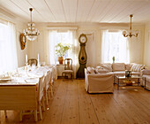 Traditionell skandinavisches Wohnzimmer mit Esstisch und Stühlen und gustavianischer Uhr