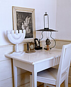 Kerzenleuchter und Uhr auf weiß lackiertem Holztisch