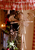 Close up detail of a traditional angel Christmas decoration suspended below a lampshade