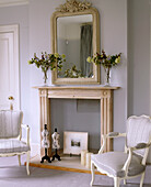 Detail of an old fireplace and large mirror in a traditional bedroom
