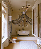 Geräumiges Badezimmer mit Badewannen-Baldachin und Toilette mit hochliegendem Spülkasten