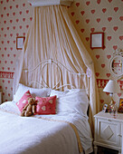 Child's bedroom with painted wrought iron bed and canopy
