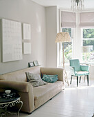 Upholstered sofa next to green chair in bay window
