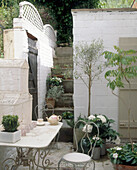 Courtyard area with plants in pots and bird cage on a table
