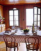 Swiss chalet dining room with wood panelling and table set for meal