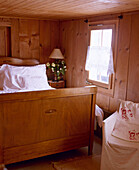 Swiss chalet bedroom with wood panelling bed and covered armchair