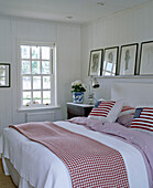 Double bed with American flag cushions in wood panelled bedroom
