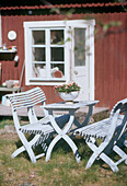 Gartentisch und Stühle auf dem Rasen vor dem Haus