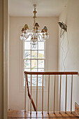 Glass chandeliers and bird ornament with wooden banister in Port Issac beach house Cornwall