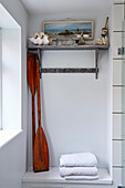 Vintage oars and folded towels with wall mounted shelf in Shoreham by Sea home West Sussex, UK