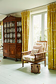 Upholstered chair and cabinet in Cotswold home of textile designer, UK