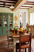 Vintage table and chairs with green cabinet in beamed kitchen Lot et Garonne, France