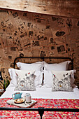 Metal framed bed in room decorated with vintage newspaper Lot et Garonne, France