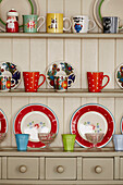 Variety of cups and plates on painted dresser in Bridport kitchen Dorset, UK