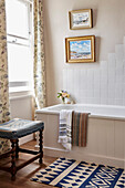 Floral curtains at open sash window in bathroom of 17th century Hampshire home, UK