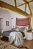 Schlafzimmer in einem reetgedeckten Landhaus aus dem 17. Jahrhundert mit Stoffen aus dem Souk in Tanger, Hampshire, England, UK