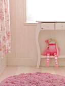 Rag doll on console shelf under window with pink rug