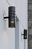 Wall mounted metal lanterns at whitewashed entrance