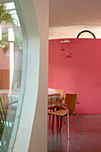 Smoothed concrete floor to dining room decorated in pink a colour which stimulate appetite