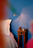 Bedside table with lamp set against blue wall