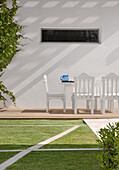 Eating area and swimming-pool with garden furniture and grass with lineal drawings in Lapacho wood