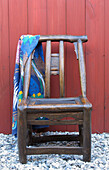Beach towel hangs on back of salvaged wooden chair