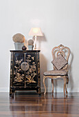 Gold upholstered chair and Oriental cabinet with lamp