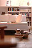 Schreibtischlampe beleuchtet offenes Buch auf weißem Sofa